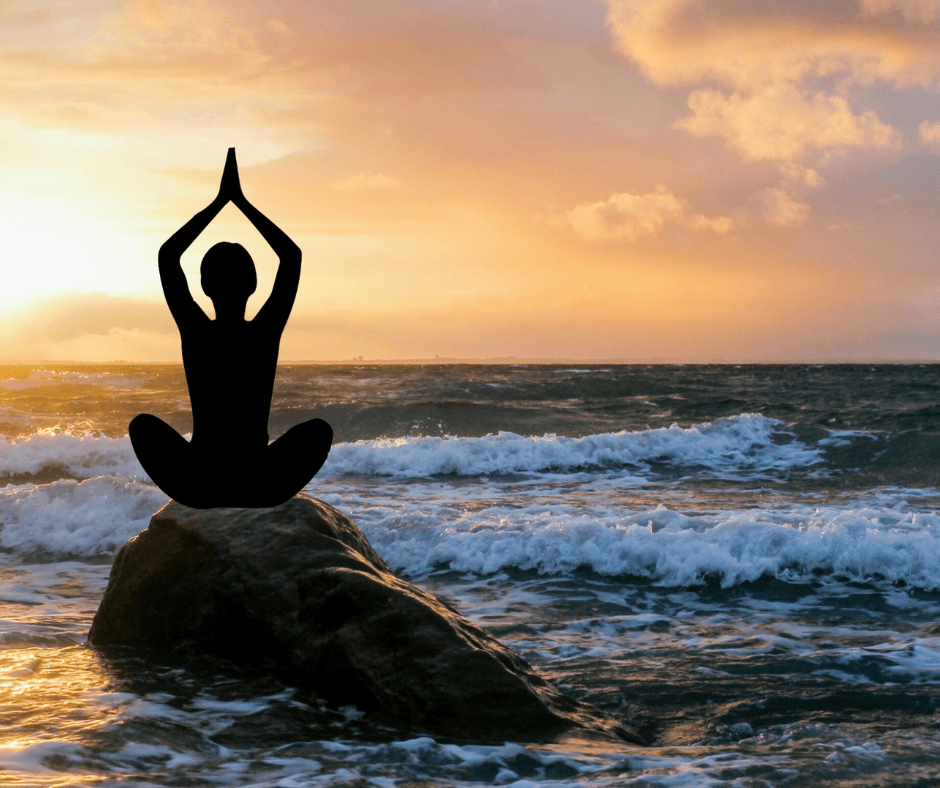 a woman is doing yoga on beach